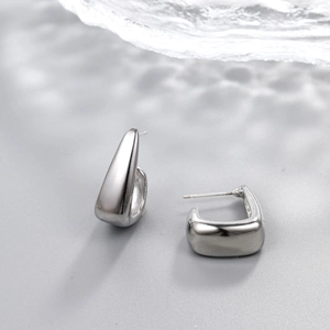 Macro view of silver geometric teardrop earrings with a high-polished mirror finish