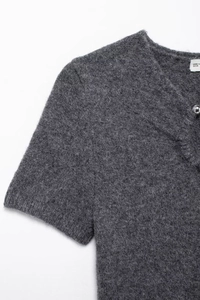 Detail shot of grey knitted short sleeve dress with V-neck and decorative button detail