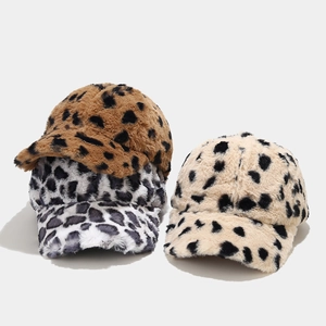 Close-up of soft plush leopard print baseball caps showing faux fur texture in three colors