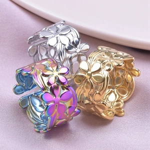 Detailed view of silver, gold, and rainbow floral rings on purple silk fabric background