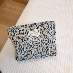 Detailed close-up of quilted floral cosmetic bag featuring Time to Party woven label