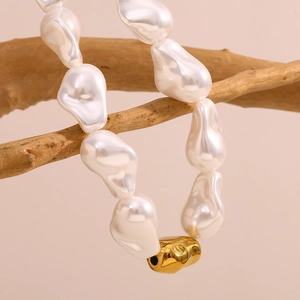 Collier de perles baroques et bille d'or 18K suspendu sur une branche en bois