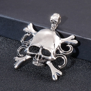 Macro detail of silver pirate skull pendant with crossbones on black surface