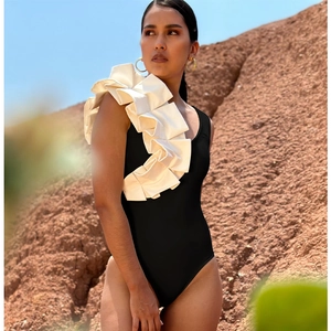 Detail of black swimsuit featuring a striking white ruffled shoulder design for women