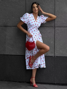 Detail of white cotton wrap dress with red heart print and puffed short sleeves