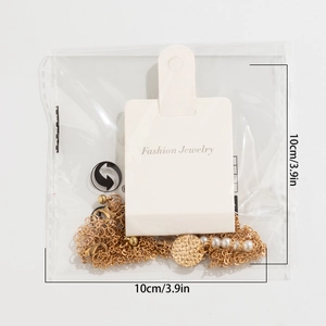 Detail of layered gold necklace with pearls and pendants in retail packaging with size labels