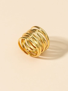 Detailed view of layered gold-tone metal ring bands with a stylish stacked design