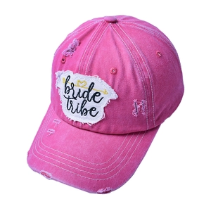 Detail of rose pink washed denim baseball cap featuring bride tribe embroidery and distressed holes