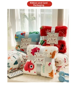 Detail of Christmas flannel blankets in festive colors with gift ribbon and product card