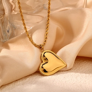 Elegant gold heart pendant necklace with twisted rope chain on silk background