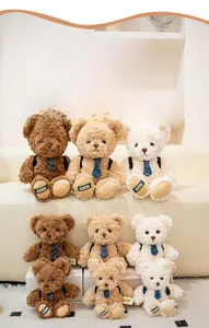 Detail of plush teddy bears in multiple sizes and colors with blue ties on a sofa