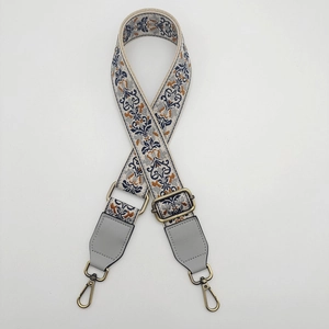 Detail of adjustable 38mm embroidered canvas bag strap with bronze metal hooks