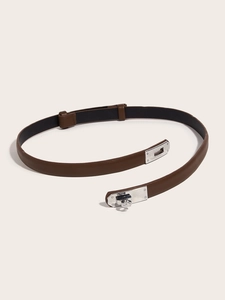 Detail of a brown leather slim belt featuring a polished silver turn-lock buckle
