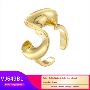 Macro view of gold brass ring featuring organic wavy design and smooth polished texture