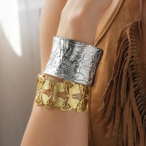Detail of bohemian wide metal cuffs featuring floral relief and hollow butterfly patterns