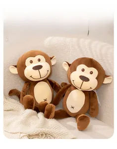 Close-up of two brown plush monkey toys with soft fur texture on a white sofa