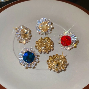 Macro shot of vintage style starburst stud earrings with colorful zircon in a tray