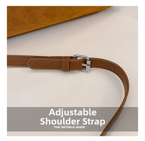 Detail of adjustable brown leather strap with silver buckle on yellow suede handbag