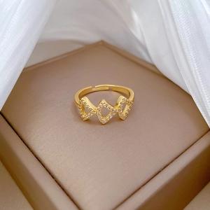 Adjustable golden ginkgo skirt ring with geometric triangle pavé crystals shown on leather