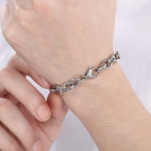 Close-up of silver stainless steel curb chain bracelet with lobster clasp on wrist