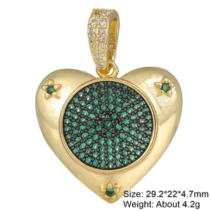Macro shot of gold heart pendant with green cubic zirconia and star patterns