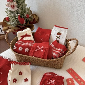 Festive red and beige crew socks with embroidery and lace trim in a gift basket