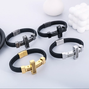Top view of four braided leather bracelets with stainless steel crosses in various finishes