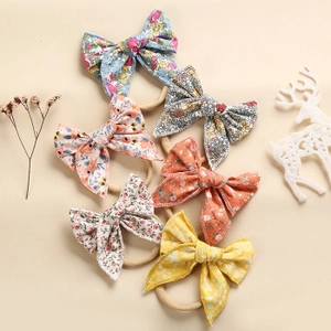Detailed set of 6 floral bow baby headbands in soft nylon for infants and newborns