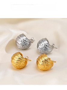 Gros plan de boucles d'oreilles géométriques or et argent à surface ondulée