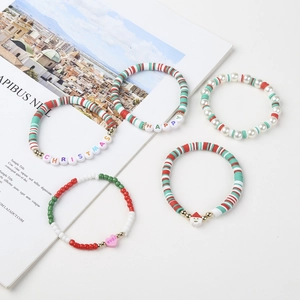 Detailed close-up of a 5-piece handmade Christmas bracelet set with festive beads and charms