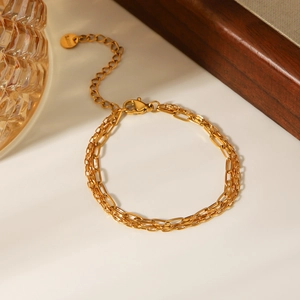 Detail of 18k gold plated stainless steel layered bracelet with lobster clasp and tag