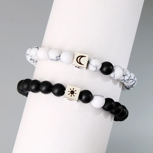 Detail of sun and moon couple bracelets with marble white and matte black beads