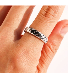 Close-up of silver ring with twisted braided texture showing metallic luster and detail