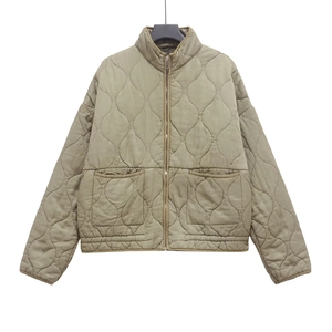 Detailed view of olive green quilted jacket featuring a stand collar and large front pockets
