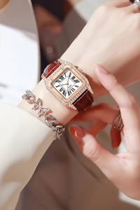Close-up of square rose gold quartz watch with rhinestones and a brown leather strap