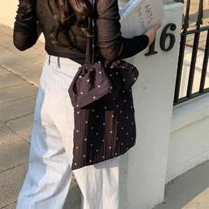 Detail of floral black canvas tote bag featuring cute bow knot and ruffled strap