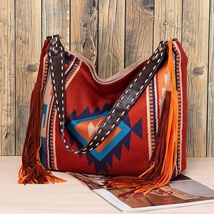Close-up of bohemian woven tote bag with tribal geometric patterns and colorful fringe