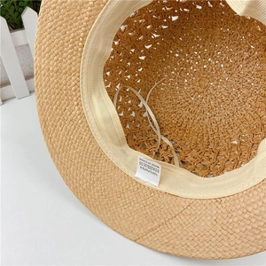 Detail of hand-woven straw sun hat interior with sweatband and 100% paper material label