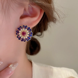 Vintage flower earrings with blue enamel, faux pearls and crystals on a model's ear