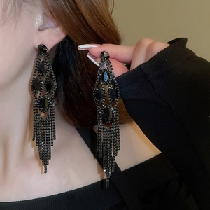 Long black rhinestone tassel earrings with a cascading drop design on model's ear