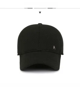 Front view of black baseball cap with silver metal M logo and twill texture detail