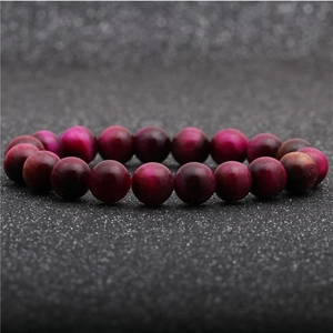 Macro shot of rose red tiger eye beads showing the natural chatoyancy effect on the bracelet