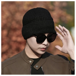 Close-up of black ribbed knit beanie showing high-quality texture on a male model