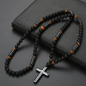Detailed shot of tiger eye and obsidian beads with a silver cross pendant on leather