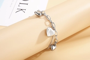 Gros plan d'un bracelet double couche en acier inoxydable avec pendentifs coeur