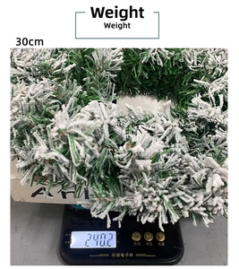 Detail showing the 30cm snow-flocked Christmas wreath being weighed at 240.2g on a scale