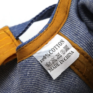 Détail de l'étiquette 100% coton du chapeau denim avec conseils d'entretien