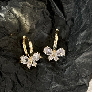 Sparkling butterfly earrings with gold finish and zircon stones on a black background