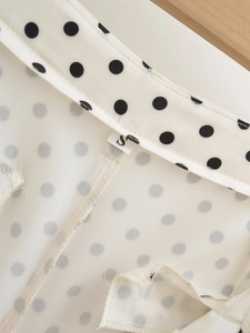 Detail of inner stitching and S-size label on cream polka dot shorts for women