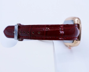 Detailed view of red crocodile-pattern leather strap with rose gold luxury watch case